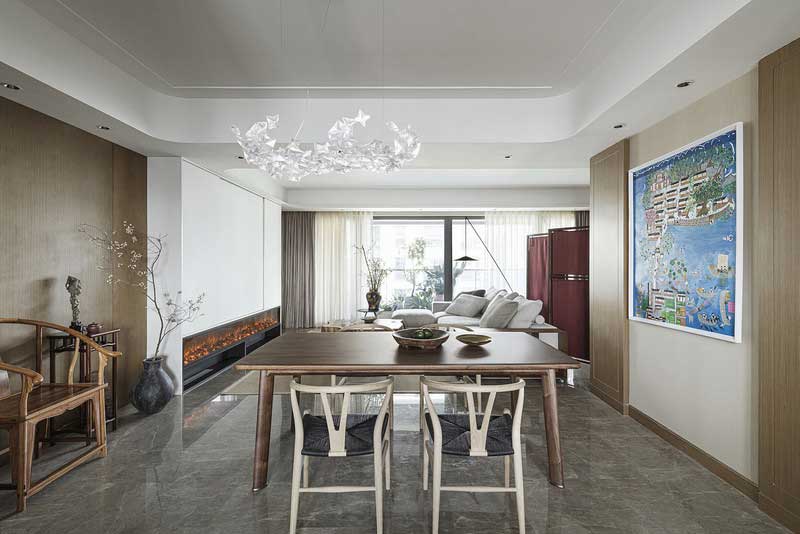 餐廳 ···改造關(guān)鍵詞：簡(jiǎn)素明凈 星影流溢 ··· 餐廳依舊延續(xù)空間整體的原木色調(diào)，簡(jiǎn)素凈潔，墻上的藍(lán)色畫作帶來了一抹明麗。半木信使之函長餐桌擁有著寬闊而飽含自然肌理的北美黑胡桃實(shí)木臺(tái)面，形如靈獸四蹄的實(shí)心黃銅墊腳,讓橢圓的桌腿弧線更加精致，如此，品嘗美食的樂享時(shí)光就有了最好的背景。