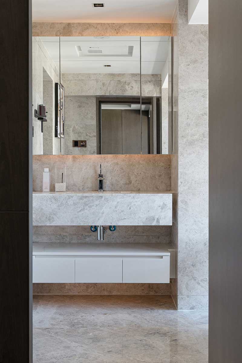 主衛(wèi)通鋪淺色暗紋大理石，搭配內(nèi)嵌式臺(tái)盆、定制同款浴室柜，整體感非常強(qiáng)，視覺(jué)上也增大了空間感。三分離的設(shè)計(jì)讓空間的使用舒適感大大提升。