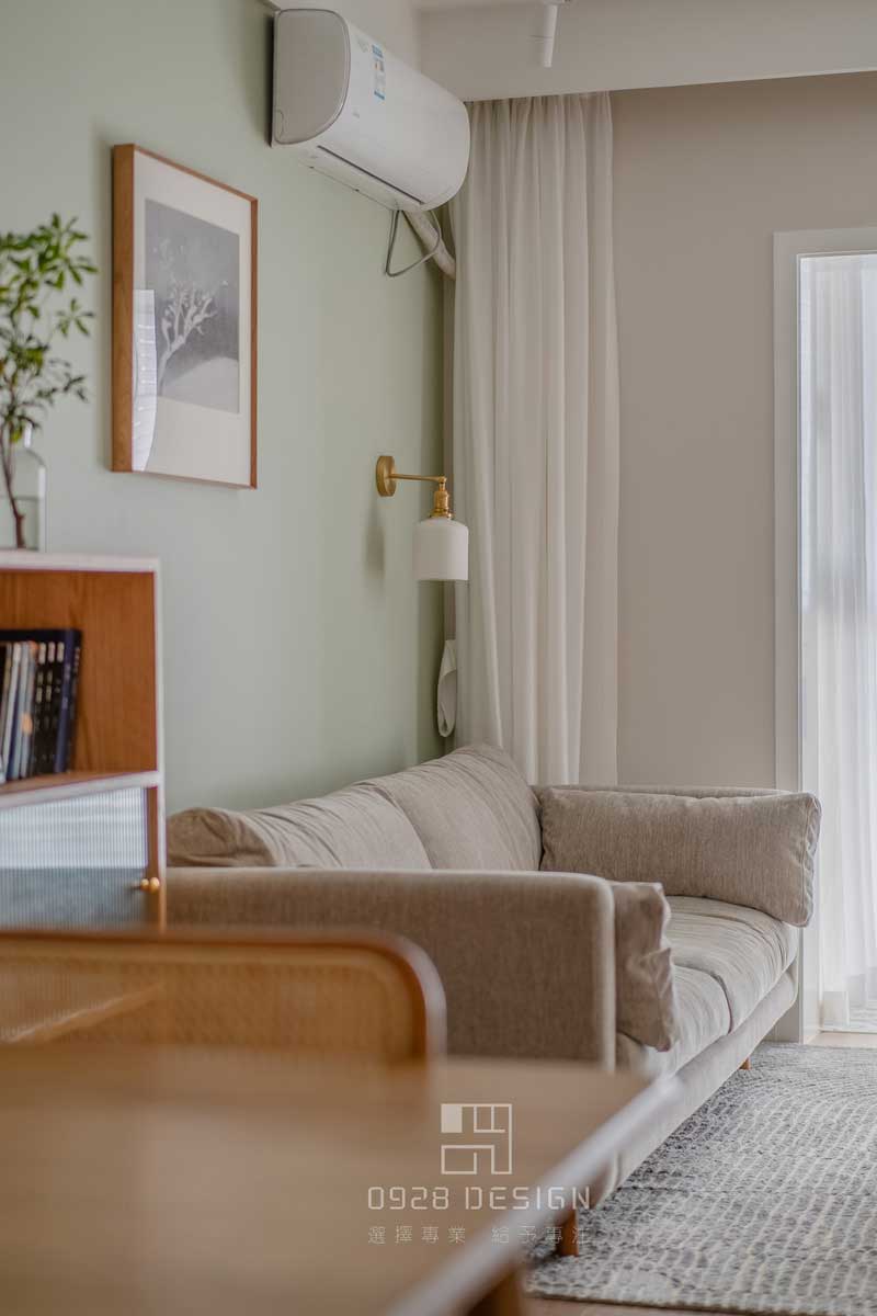 沙發(fā)背景灰綠色的墻面，增加了一點俏皮感，在沙發(fā)背景掛畫的選擇上沒有用常規(guī)的形式，單一幅正方形的雪景圖，加深了深遠悠長的感受。壁燈選擇瓷器的燈罩和金色的吊桿，點綴精致感又帶有復古的意味，和餐廳吊燈是一套購買。