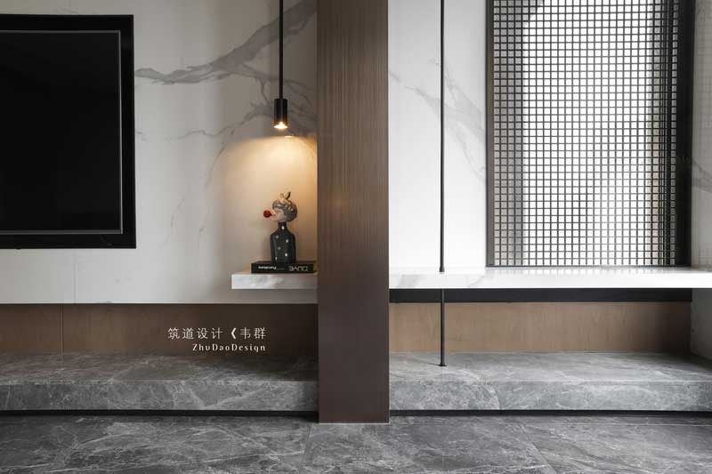 原本木飾面這塊是承重柱，為了弱化它的存在感，設計師通過穿插的手法，將線條穿插過來，空間有了靈動性，不會顯得呆板。