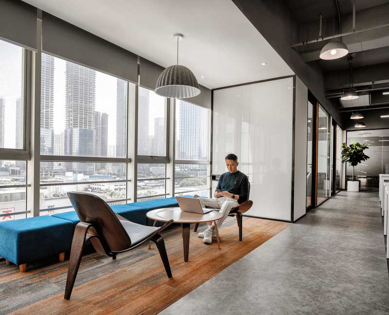 辦公室臨窗休息區(qū)藍色的布藝沙發(fā)效果圖