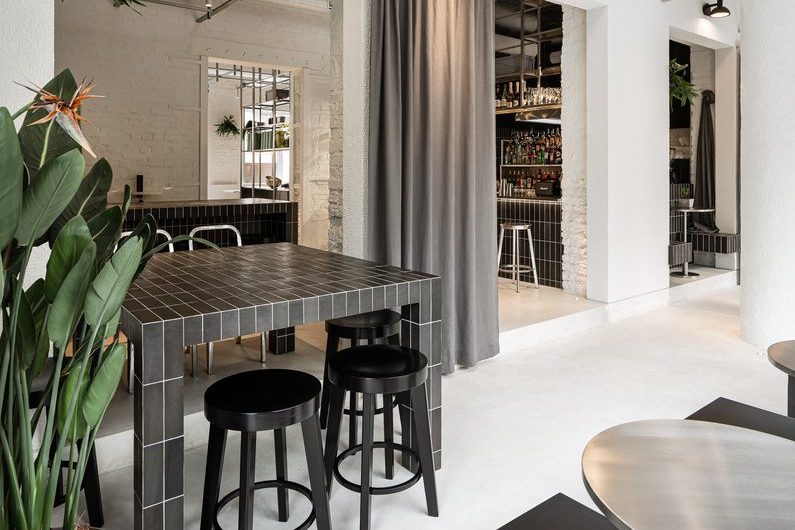簡約工業(yè)風(fēng)咖啡廳黑色方磚餐桌搭黑色圓凳裝修圖