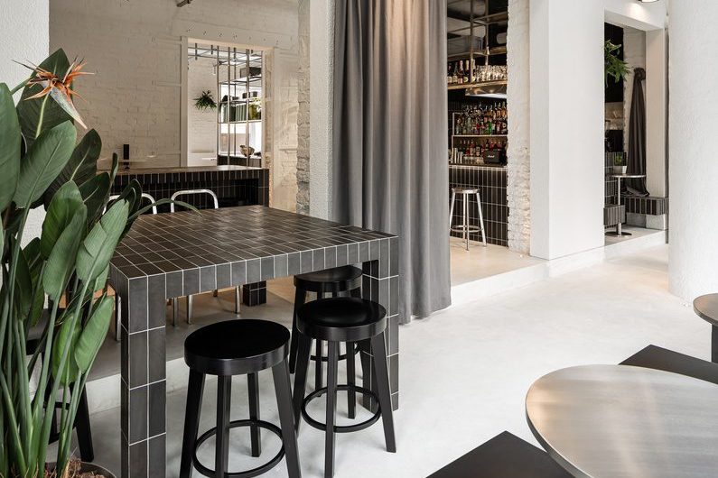簡(jiǎn)約工業(yè)風(fēng)咖啡廳黑色方磚餐桌搭黑色圓凳裝修圖